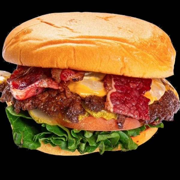 Loaded cheeseburger with bacon, melted cheese, tomato, pickles, and lettuce on a toasted brioche bun.
